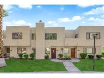 Inviting townhouse featuring a manicured lawn, desert landscaping and neutral color scheme at 2661 Ruthe Duarte Ave, Las Vegas, NV 89121