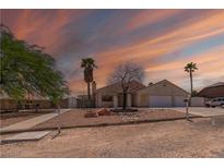 Charming single-story home featuring desert landscaping, a two-car garage, and a picturesque sunset at 475 E Robindale Rd, Las Vegas, NV 89123