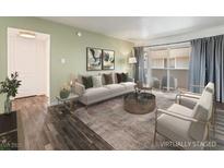 Inviting living room featuring hardwood floors, neutral paint, stylish furniture and a sliding glass door at 753 Oakmont Ave # 802, Las Vegas, NV 89109