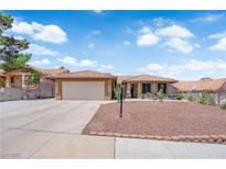 Charming single-story home featuring a tile roof, desert landscaping, and a two-car garage at 903 Billings St, Henderson, NV 89002