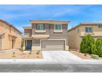 Two story home featuring neutral toned stucco, two car garage and low maintenance landscaping at 9766 Marcelline Ave, Las Vegas, NV 89148