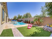 Sparkling pool and spa with a luxurious patio area, perfect for relaxing and entertaining in your backyard oasis at 9779 Mosaic Canyon Ct, Las Vegas, NV 89149