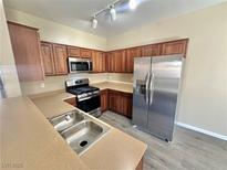 Well-lit kitchen features stainless steel appliances and wood cabinetry at 10455 Alpine Edge Ave, Las Vegas, NV 89129