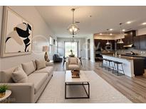 Bright, open-concept living room with modern decor, flowing seamlessly into dining and kitchen areas at 12565 Huckleberry Oak Ave, Las Vegas, NV 89138