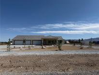 Charming single-story home with three-car garage and desert landscaping at 1351 Huckleberry St, Pahrump, NV 89048