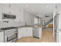 Modern kitchen featuring stainless steel appliances, white cabinets, and an open layout connected to the living area at 305 Napa Hills Dr, Las Vegas, NV 89144