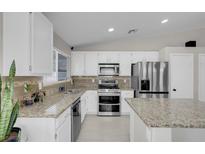 Bright kitchen with white cabinets, granite countertops, stainless steel appliances, and tile flooring at 509 Regal Robin Way, North Las Vegas, NV 89084