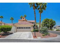 Charming home featuring a two-car garage and desert landscaping with mature palm trees at 5237 Crooked Sky Cir, Las Vegas, NV 89149
