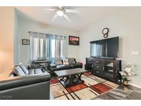 Inviting living room featuring hardwood floors, plush sofas, TV set, ceiling fan, and natural light at 6321 Rolling Rose St # 201, North Las Vegas, NV 89081
