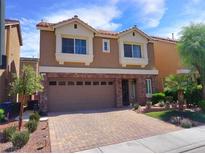 Charming two-story home with a brick-accented front, manicured landscaping, and a paved driveway at 6729 Flamenco Ct, Las Vegas, NV 89139