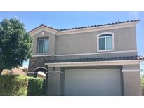 Charming two-story home with a stone accent, a two-car garage and landscaped yard at 6812 Dipper Ave, North Las Vegas, NV 89084