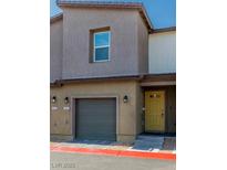 Two-story townhouse featuring a one-car garage, a yellow door, and a simple, modern design at 7977 Whisper Words Ave, Las Vegas, NV 89113