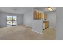 Bright living room with sliding glass doors to balcony and adjacent kitchen space at 8000 Badura Ave # 2174, Las Vegas, NV 89113