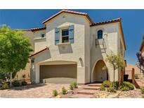 Charming two-story home boasts tan stucco, a red tile roof, a two-car garage, and desert landscaping at 10024 Rams Leap Ave, Las Vegas, NV 89166
