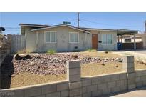 Charming single-story home with a rock-landscaped front yard, carport, and neutral color palette at 129 Maple St, Henderson, NV 89015