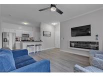Bright living space featuring sleek gray floors, a modern fireplace, and an open kitchen at 2900 Sunridge Heights Pkwy # 1916, Henderson, NV 89052