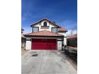 Two-story home featuring a red tile roof, white exterior, and a two-car garage with a bold red door at 6374 Horizon Ridge Ct, Las Vegas, NV 89156