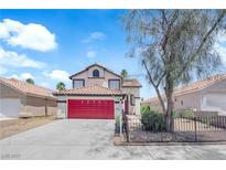 Charming two-story home features a red garage door, a tile roof, and well-maintained landscaping at 6374 Horizon Ridge Ct, Las Vegas, NV 89156