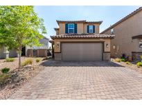 Inviting two-story home featuring a brick driveway, charming shutters, and a spacious two-car garage at 9690 Langden Brook St, Las Vegas, NV 89178