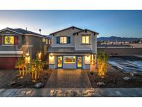 Charming two-story home with a well-maintained front yard, brick driveway, and mountain views at sunset at 2642 Begonia Falls Ave # 40, North Las Vegas, NV 89081