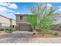 Charming two-story home featuring a well-manicured yard and a two-car garage on a beautiful, sunny day at 311 Lilian Faith Ave, North Las Vegas, NV 89031