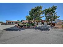 Charming single-story home with mature trees, desert landscaping, and an American flag in the front yard at 5725 N Durango Dr, Las Vegas, NV 89149