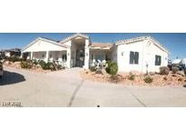 Inviting single story home featuring a desert landscape, covered porch, and long driveway at 60 N Fogg St, Las Vegas, NV 89110