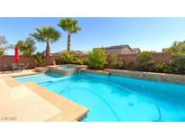 Inviting backyard pool and spa area perfect for outdoor relaxation and entertaining with lush landscaping at 6403 Brandon Hills Ct, Las Vegas, NV 89139