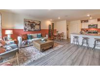 Inviting living room with a modern sofa, stylish rug, and an open layout to the kitchen and dining area at 6926 Wrightshire St # 20, Las Vegas, NV 89166