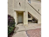 A charming condo entrance with a cozy bench, a tidy garden, and a stucco facade at 698 S Racetrack Rd # 1411, Henderson, NV 89015