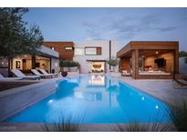 Stunning backyard pool with a modern cabana and sleek lounge chairs at 7030 Schirlls St, Las Vegas, NV 89118