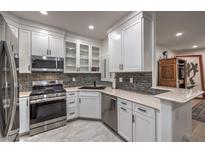 This modern kitchen features white cabinetry, stainless steel appliances, and stylish backsplash at 75 N Valle Verde Dr # 211, Henderson, NV 89074