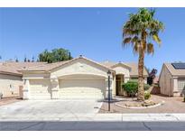 Inviting single-story home featuring a three-car garage and desert landscaping at 7544 Coral River Dr, Las Vegas, NV 89131