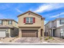 Charming two-story home featuring a brick driveway, two-car garage, red shutters, and low-maintenance landscaping at 9114 Riverlands Ranch St, Las Vegas, NV 89139