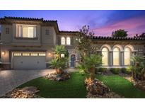 Stunning two-story home with a beautiful tile roof, lush landscaping, and a paver driveway at 2577 Luberon Dr, Henderson, NV 89044