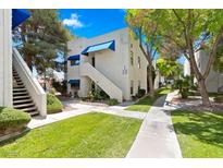 Well-maintained home exterior with green lawn, mature trees, and a private entryway at 2643 Red Rock St # 201, Las Vegas, NV 89146