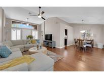 Inviting living room with a sectional sofa, hardwood floors, and large windows creating a bright and airy space at 2701 Glencliff Dr, Las Vegas, NV 89134