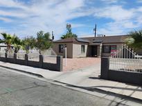 Charming single-story home with light brown siding, solar panels, gated yard and rock landscaping at 4525 Fulton Pl, Las Vegas, NV 89107