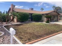 Charming single-story home featuring desert landscaping with a fresh lawn, palm trees, and a brick exterior at 5821 Santa Catalina Ave, Las Vegas, NV 89108