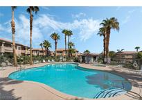 Community swimming pool with palm trees and blue skies on a sunny day, perfect for relaxation and recreation at 8410 Eldora Ave # 2046, Las Vegas, NV 89117