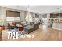 Open-concept living room with a large sectional sofa, wood floors, and a view of the kitchen at , Las Vegas, NV 89139