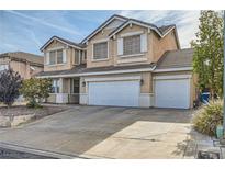 Two-story home with a three-car garage and a well-manicured front yard featuring desert landscaping at 104 Glendive St, Henderson, NV 89012