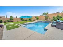 Inviting pool area with a sun umbrella, manicured lawn, and a soothing waterfall feature at 10601 Skye Arroyo Ave, Las Vegas, NV 89166