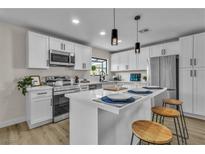 Modern kitchen features white cabinets, stainless steel appliances, and a quartz countertop island with seating at 2211 Frontier Ave, Las Vegas, NV 89106