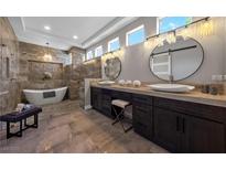 Elegant bathroom featuring dual sinks, modern fixtures, freestanding tub and a separate shower at 2548 Faiss Dr, Las Vegas, NV 89134