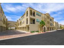 Beautiful stucco condo building featuring arched entrances and balconies, set against a sunny sky at 2555 Hampton Rd # 9307, Henderson, NV 89052