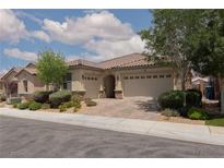 Charming single story stucco home with a paver driveway, three-car garage and desert landscaping at 3084 Porte La Paz Ave, Henderson, NV 89044