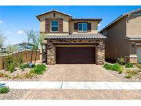 Charming two-story home with a stone-accented facade, a brick driveway, and a well-maintained front yard at 440 Blue Lark Dr, Henderson, NV 89011