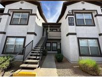 Exterior of a two-story apartment building featuring multiple windows and a central staircase leading to upper units at 45 Maleena Mesa St # 1321, Henderson, NV 89074