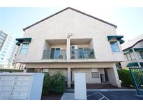 Two-story condo featuring a balcony with green awning and stucco exterior finish at 450 Elm Dr # 105, Las Vegas, NV 89169